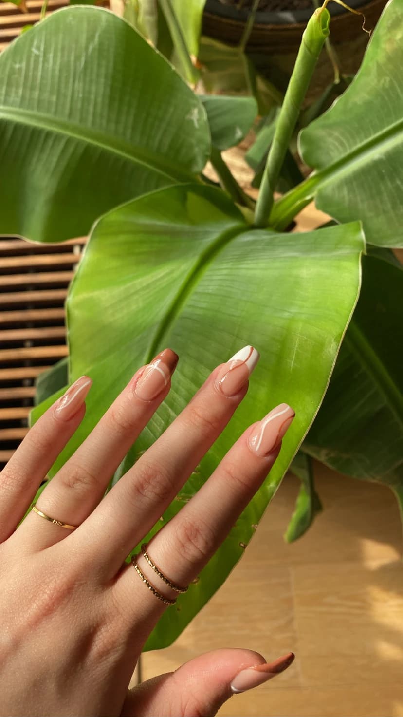 Nude French nagels bij een plant